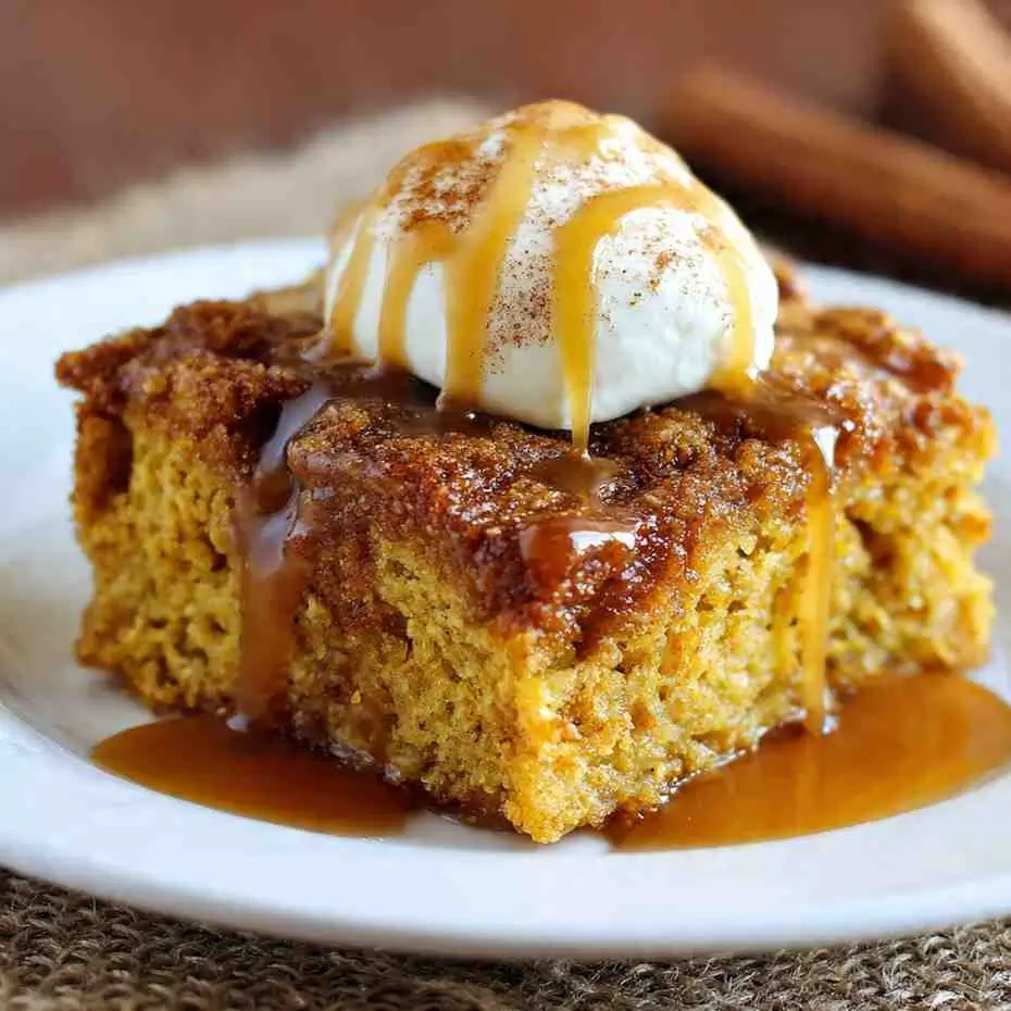 Pumpkin Dump Cake with Yellow Cake Mix slice topped with caramel sauce and whipped cream.